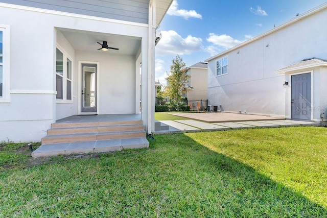 exterior space featuring central AC unit, a lawn, and ceiling fan