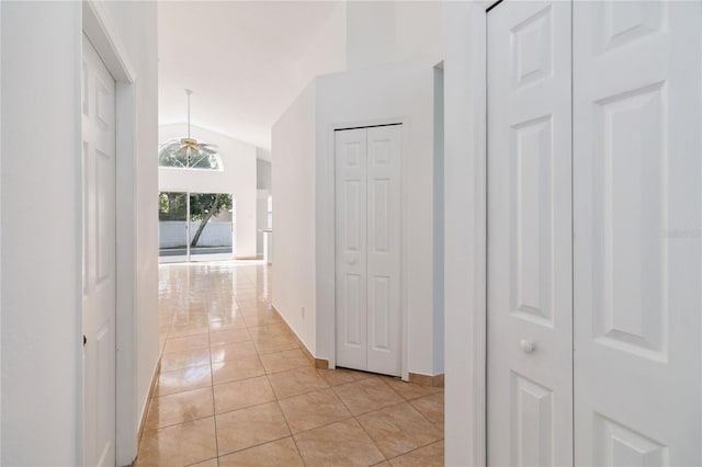 hall with lofted ceiling and light tile patterned floors