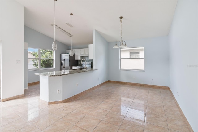 kitchen featuring stainless steel refrigerator with ice dispenser, kitchen peninsula, dark stone counters, vaulted ceiling, and white cabinets