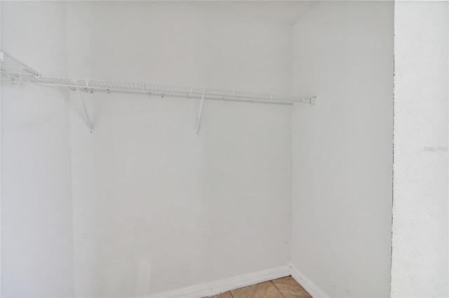 spacious closet with light tile patterned floors