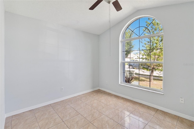 tiled spare room with a wealth of natural light, lofted ceiling, a textured ceiling, and ceiling fan