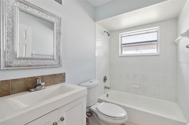 full bathroom featuring tiled shower / bath, vanity, and toilet