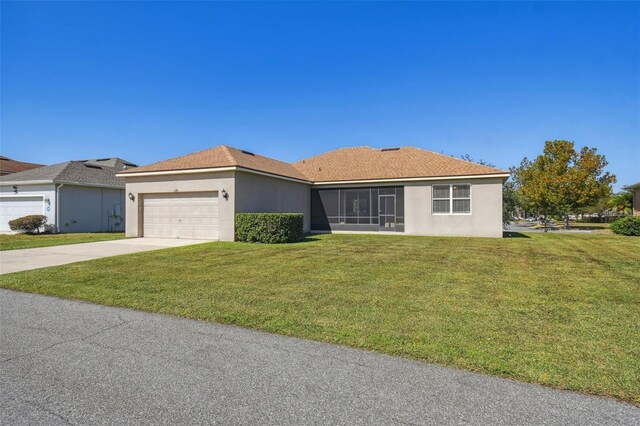 ranch-style home with a garage, concrete driveway, a front lawn, and stucco siding