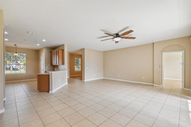 kitchen with ceiling fan, decorative light fixtures, kitchen peninsula, and light tile patterned floors