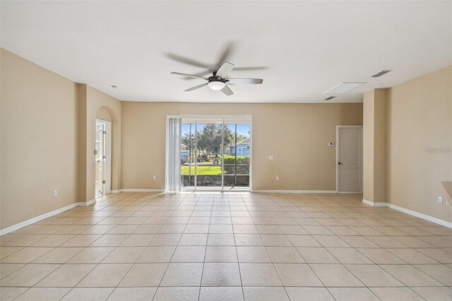 unfurnished room featuring visible vents, light tile patterned flooring, arched walkways, baseboards, and ceiling fan