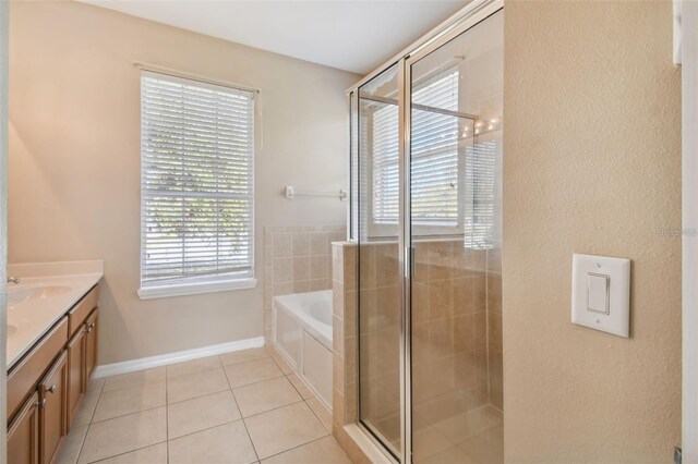 full bath featuring tile patterned floors, a garden tub, vanity, and a shower stall