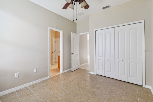 unfurnished bedroom featuring light tile patterned flooring, a closet, and ceiling fan