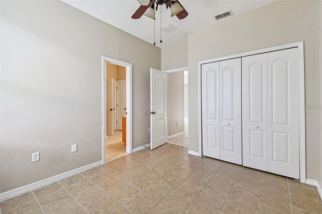 unfurnished bedroom with visible vents, connected bathroom, light tile patterned floors, a closet, and baseboards