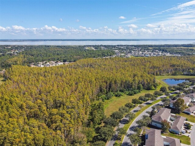 bird's eye view featuring a wooded view and a water view