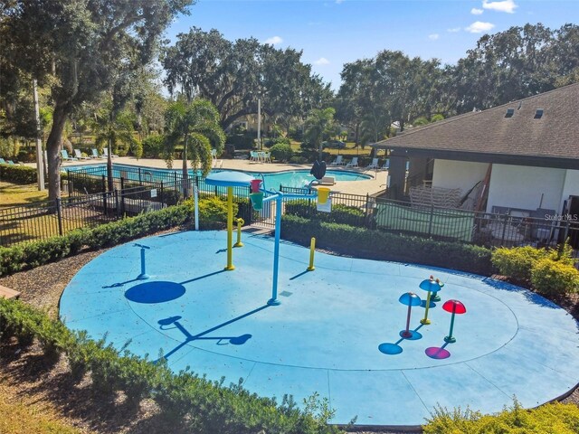 view of community featuring a swimming pool and fence