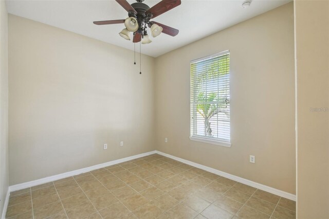 empty room with ceiling fan and baseboards