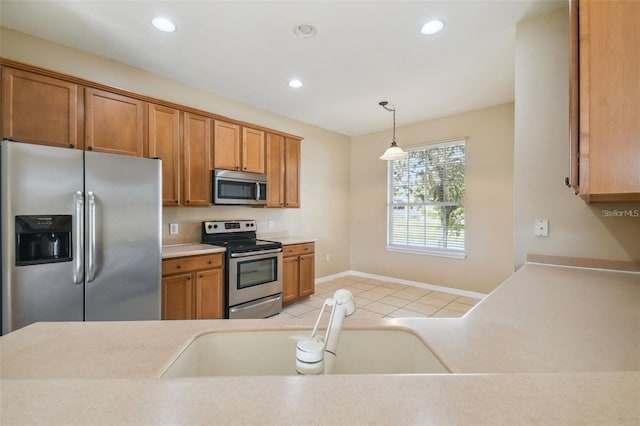 kitchen featuring light tile patterned floors, stainless steel appliances, sink, and pendant lighting