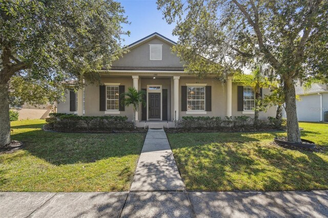 bungalow-style home with a porch, a front yard, and stucco siding
