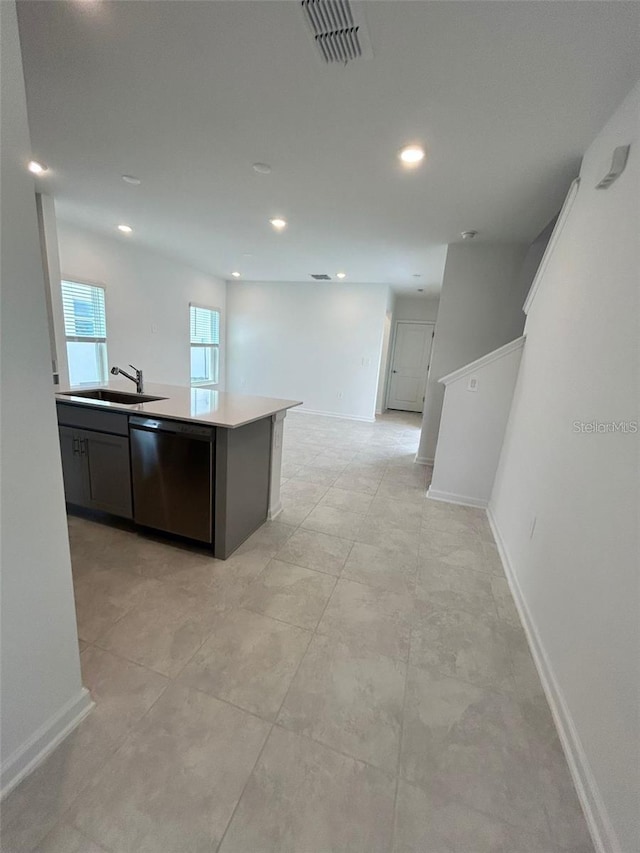 kitchen featuring dishwasher, sink, and a center island with sink