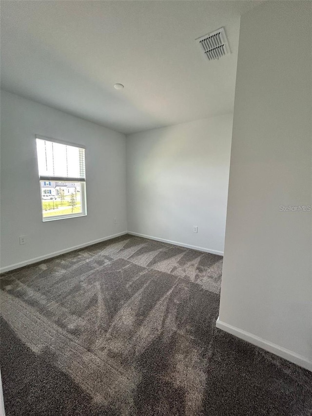 empty room featuring dark carpet