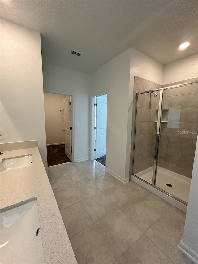 bathroom featuring vanity, tile patterned floors, walk in shower, and a textured ceiling