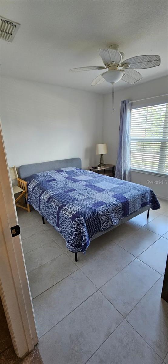 bedroom featuring light tile patterned flooring and ceiling fan