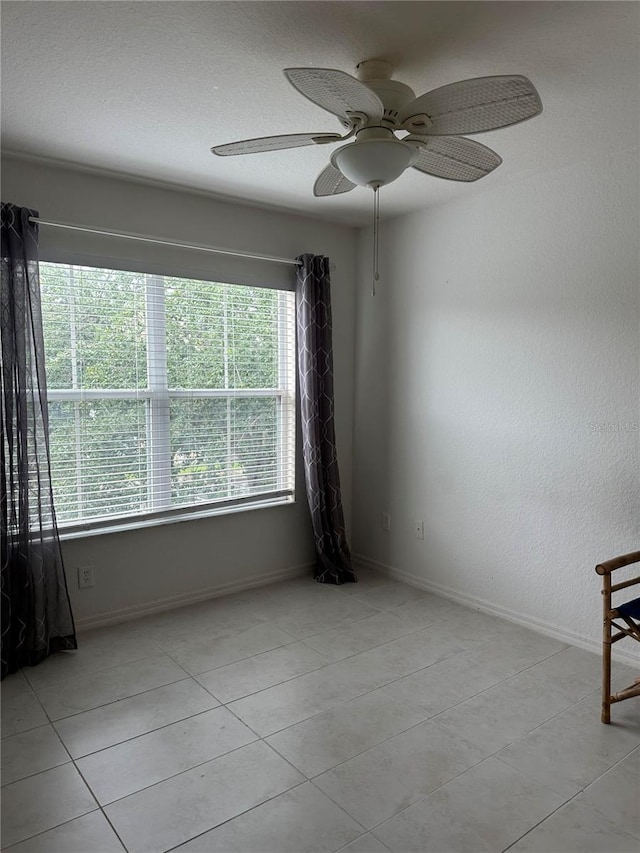 empty room featuring light tile patterned flooring and ceiling fan