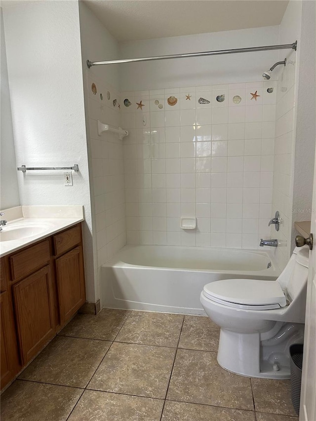 full bathroom with toilet, tiled shower / bath, vanity, and tile patterned floors