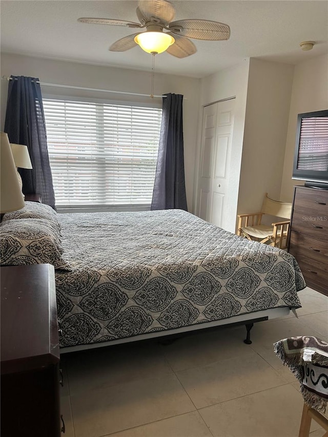 bedroom featuring tile patterned floors, a closet, and ceiling fan