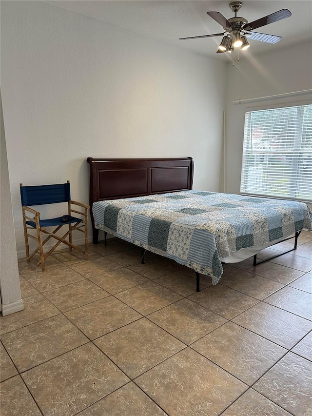 tiled bedroom featuring ceiling fan