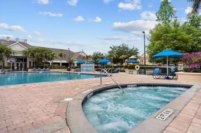 view of pool with a patio and a community hot tub