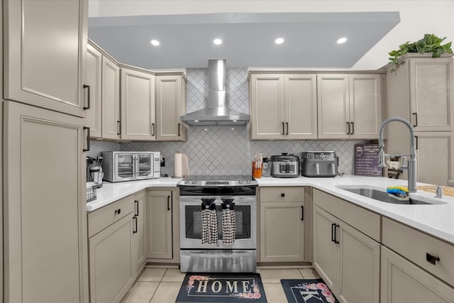 kitchen featuring wall chimney range hood, stainless steel electric stove, sink, and light tile patterned floors