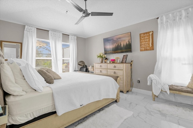 bedroom with ceiling fan and a textured ceiling