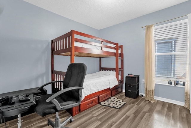 bedroom with a textured ceiling and hardwood / wood-style floors