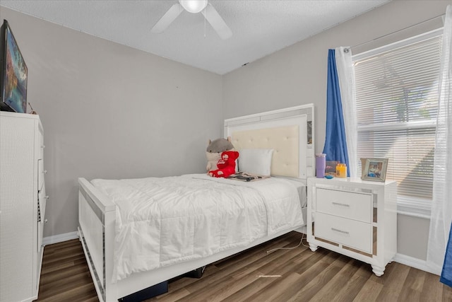 bedroom featuring ceiling fan, a textured ceiling, and dark hardwood / wood-style flooring