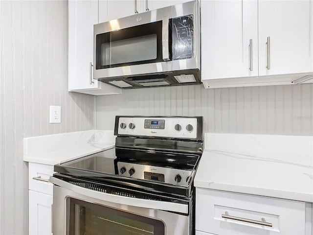 kitchen with light stone countertops, white cabinets, and stainless steel appliances