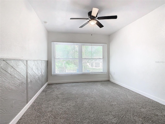 carpeted spare room featuring ceiling fan