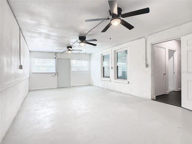 unfurnished room featuring concrete floors and ceiling fan