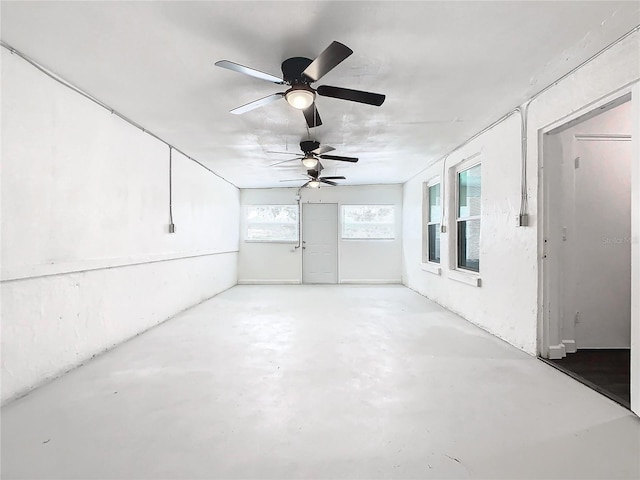 unfurnished sunroom featuring ceiling fan and plenty of natural light