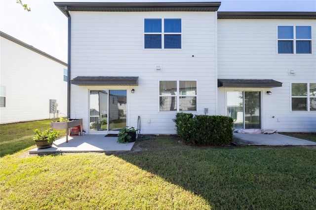 back of property featuring a patio and a lawn