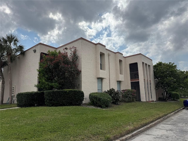 view of property exterior featuring stucco siding and a yard