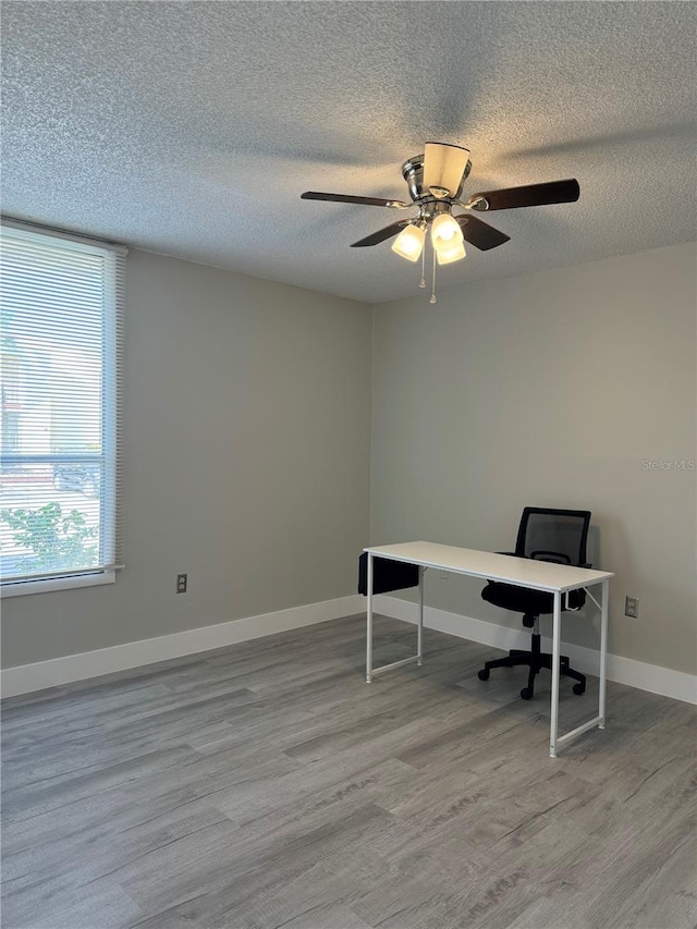 office space featuring a textured ceiling, baseboards, and wood finished floors