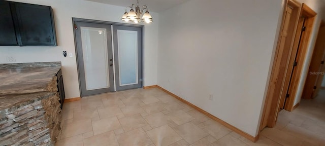 doorway featuring an inviting chandelier and french doors