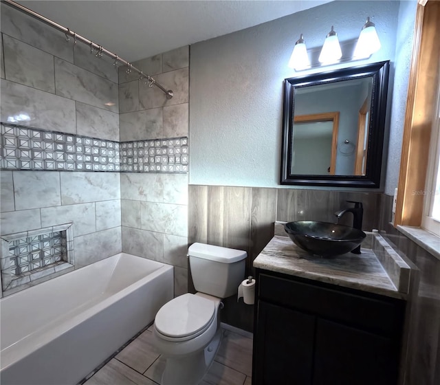 full bathroom featuring toilet, tiled shower / bath combo, vanity, and tile patterned flooring