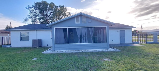 back of house with a lawn, central AC unit, and a sunroom