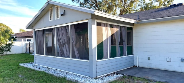 view of property exterior with a yard and a sunroom