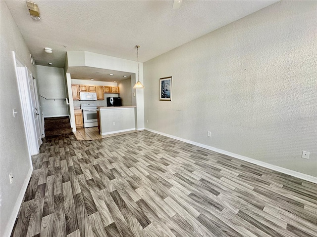 unfurnished living room with light hardwood / wood-style floors and a textured ceiling