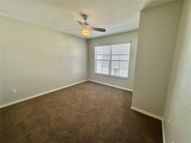 empty room with ceiling fan, dark carpet, and a textured ceiling