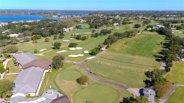 birds eye view of property with view of golf course and a water view