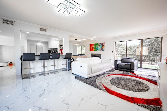 living room featuring marble finish floor, a fireplace, visible vents, and ornamental molding