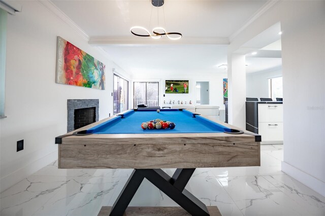 rec room featuring marble finish floor, baseboards, a fireplace, and ornamental molding