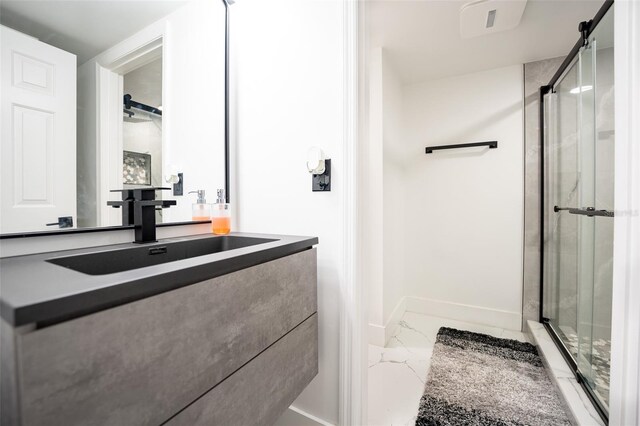 bathroom featuring marble finish floor, a shower stall, baseboards, and vanity