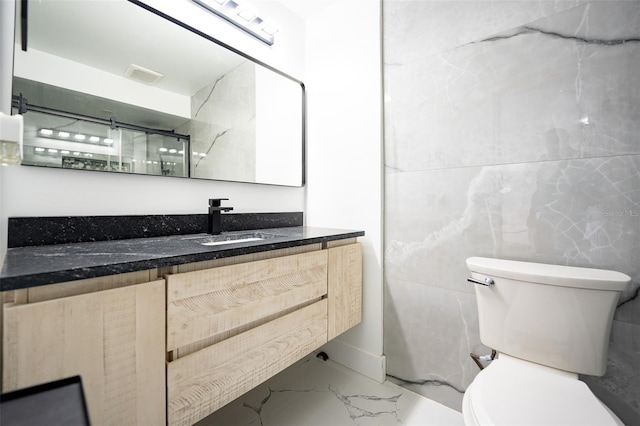 bathroom with toilet, marble finish floor, vanity, and visible vents