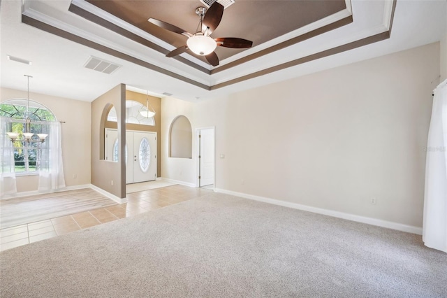 carpeted spare room with ceiling fan, crown molding, and a tray ceiling