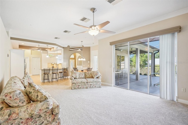 carpeted living room featuring ornamental molding and ceiling fan with notable chandelier